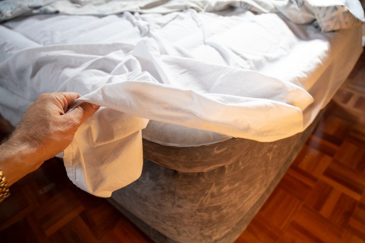 Poniendo las sábanas a una cama hinchable alta