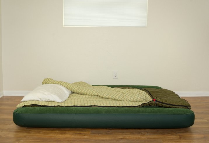 Colchón hinchable individual con almohada en una habitación