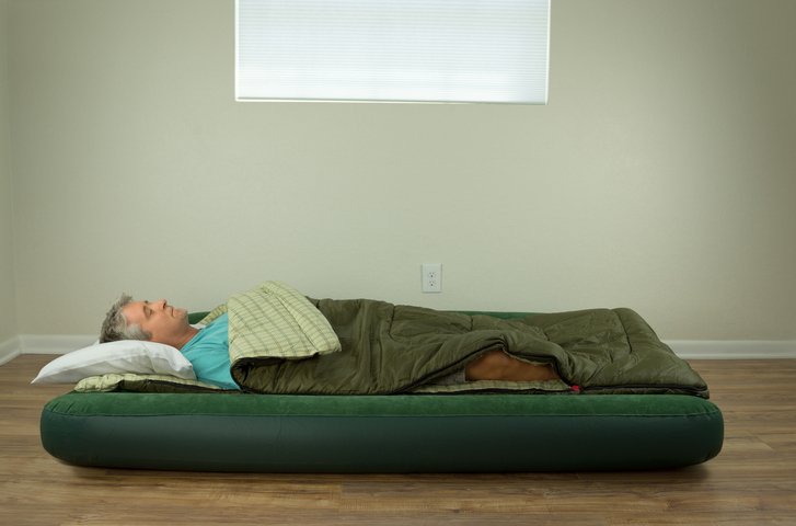 Persona durmiendo en un colchón hinchable individual