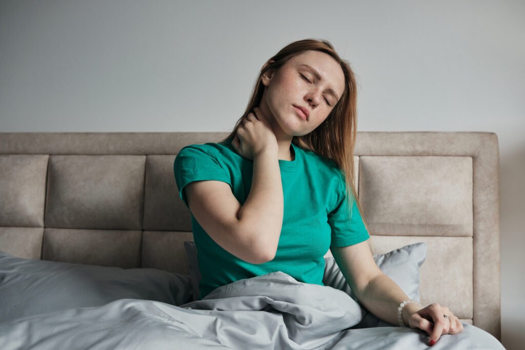 Mujer con el cuello cargado al despertar, antes de cambiar a una almohada cervical