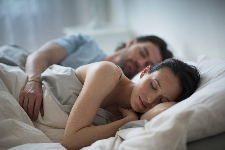 Pareja durmiendo de lado sobre las mejores almohadas para su postura