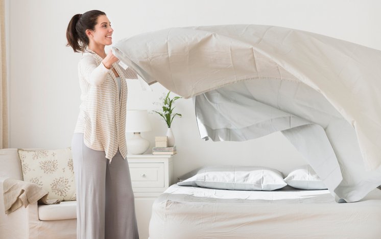 Colocando el protector de colchón al hacer la cama